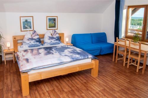 a bedroom with a bed and a blue couch at Chata Anděl in Vrchlabí