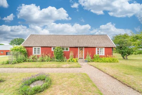 a red house with a garden in front of it at Charming Country House - Bedding & Towels included in Färjestaden