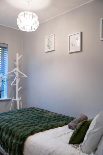a bedroom with a green blanket on a bed at Norwich, Lavender House, 3 Bedroom House, Private Parking and Garden in Norwich