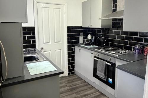 a kitchen with a sink and a stove top oven at Seaside Haven Retreat in South Shields in South Shields