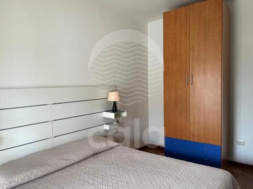 a bedroom with a bed and a wooden cabinet at Villa Stella La tina - Spiaggia a 300m By Cala Salento in Torre Lapillo