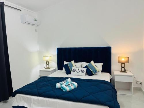 a bedroom with a blue and white bed with two lamps at Refresh Holidays in Mont Choisy