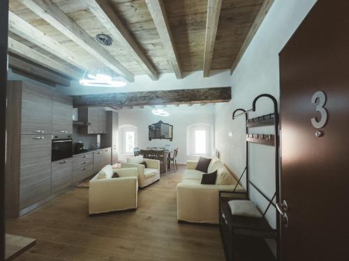 a living room with white furniture and a kitchen at Casa da Victoria in Castrezzato