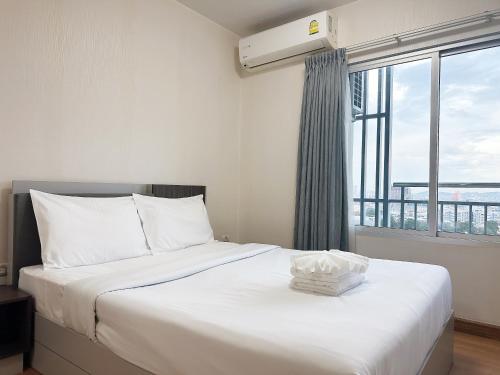 a bedroom with a large bed with a large window at Supalai Mare Pattaya & City Center in Pattaya South