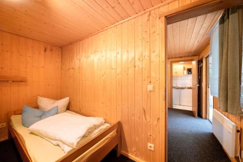 a small room with a bed in a wooden wall at Bungalow 37b - Kimbucht in Reichendorf