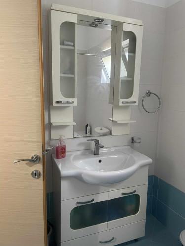 a bathroom with a sink and a mirror at Margaret's Guest House in Mesopotam
