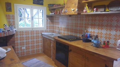 a kitchen with a wooden counter top and a window at Casa con vista in Matraia
