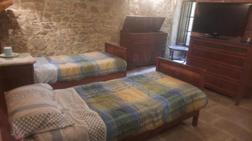 a bedroom with two beds and a dresser and a tv at Casa con vista in Matraia