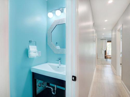 Un baño azul con lavabo y espejo. en Deja Blue B, en Tybee Island