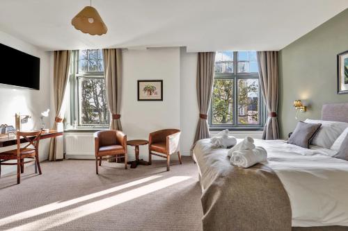 a hotel room with a bed and a desk and chairs at The Lambton in Durham