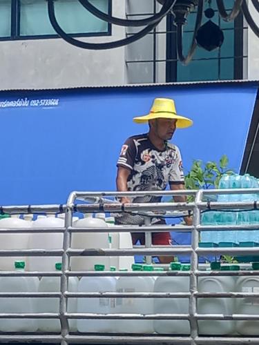 a man wearing a yellow hat standing in a cart at Sweden Inn Hostel Chalong in Ban Klang
