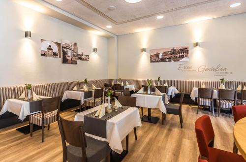 a restaurant with tables and chairs in a room at Schumanns Garten in Weißenfels