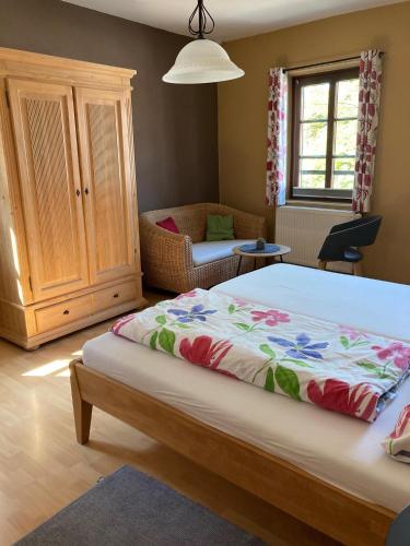a bedroom with a bed and a chair and a cabinet at Hofschänke in Winden