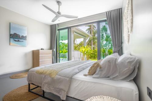 Un dormitorio con una cama y una ventana grande. en Villa MAÏA, en Koh Samui 