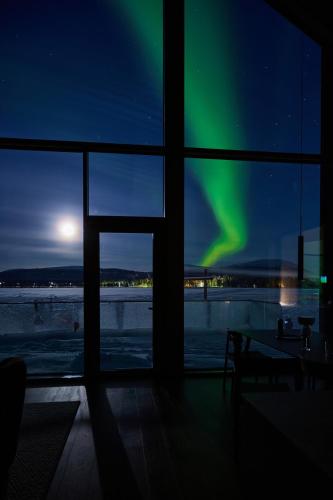 an view of the aurora from a room with a window at Joiku Luxury Lakeview Chalet in Kolari