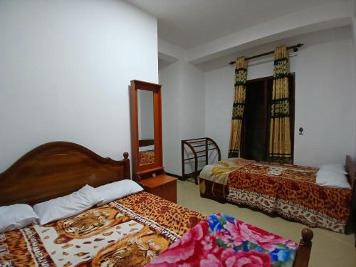 a hotel room with two beds and a mirror at Midnight Oasis in Nuwara Eliya
