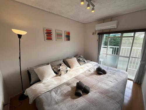 a bedroom with a large bed with two stuffed animals on it at 伊勢ヒルトップ アパートメント in Ise