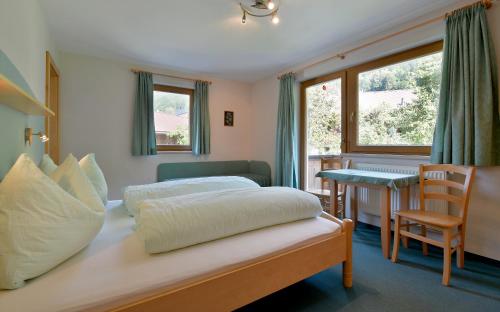 Schlafzimmer mit einem Bett, einem Tisch und einem Schreibtisch in der Unterkunft Gästehaus Wurm in Stumm