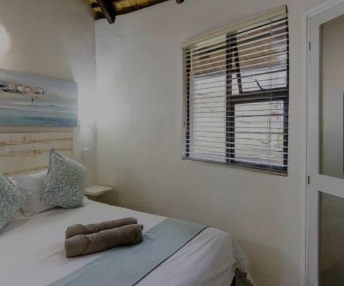 a bedroom with a bed with two towels on it at Banana Beach Club C5 in Port Shepstone