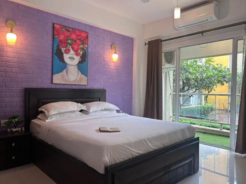 a bedroom with a large bed with a purple wall at Nayaab by Leo Homes - 2BHK Flat near Anjuna Beach in Anjuna