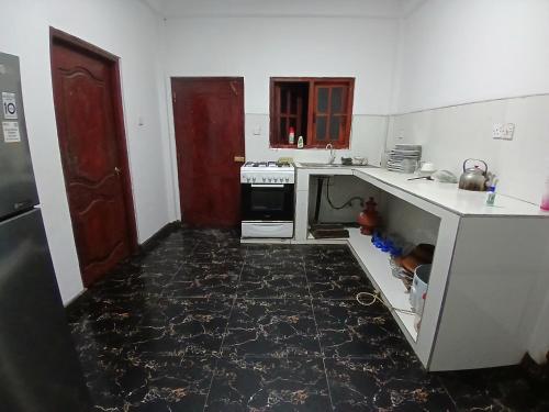 a kitchen with a black tile floor and a stove at Midnight Oasis in Nuwara Eliya