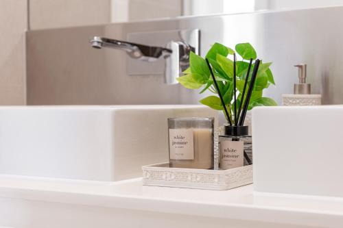 een badkamermeubel met twee kaarsen en een plant bij Island Paradise - Stylish 1BR on Bluewaters Island in Dubai