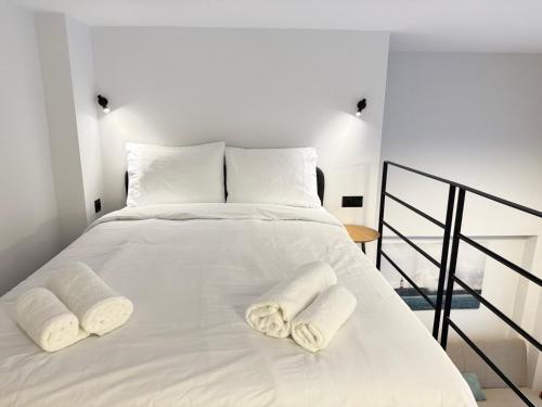 a white bed with two white towels on it at Room8 Suites in Thessaloniki