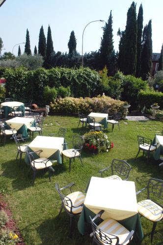 a group of tables and chairs in the grass at Hotel Smeraldo in Lazise