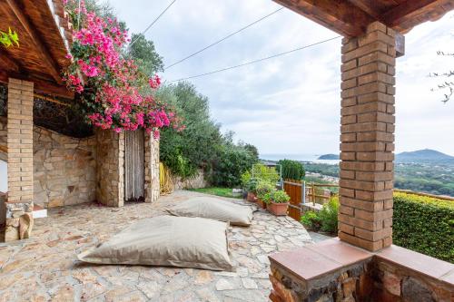 a patio with pillows and flowers on a building at Domus Sole in Campu Longu