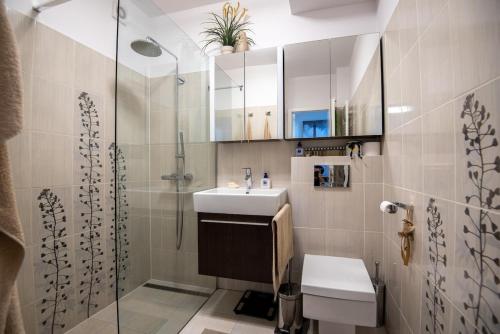 a bathroom with a sink and a shower at Charming 2-BR apartment at Nivy Bratislava in Nivy