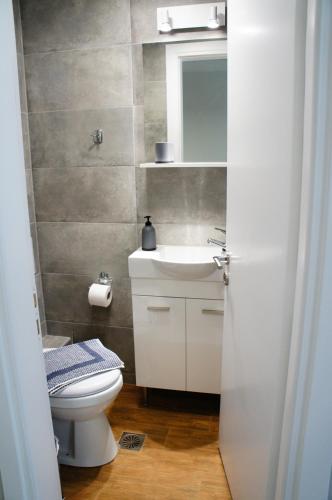 a bathroom with a sink and a toilet and a mirror at A&I Apartments & Studios in Athens
