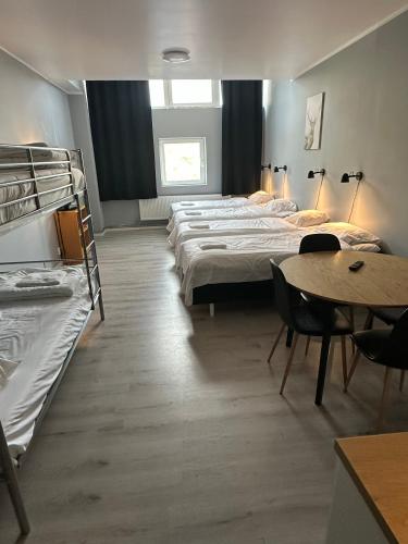 a room with three beds and a table and chairs at Hotell Salem in Stockholm