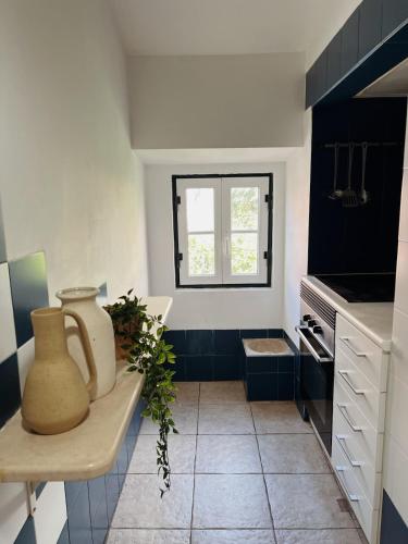 a kitchen with black and white tiles and a window at Typical Lisbon Apartment Príncipe Real in Lisbon