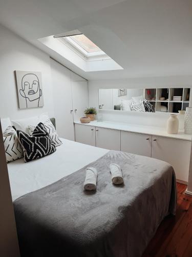 a bedroom with a bed with slippers on it at Typical Lisbon Apartment Príncipe Real in Lisbon