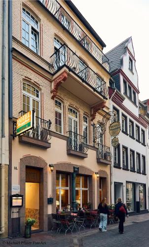 a group of people walking in front of a building at Nostalgie Altstadthotel Kornpforte in Koblenz