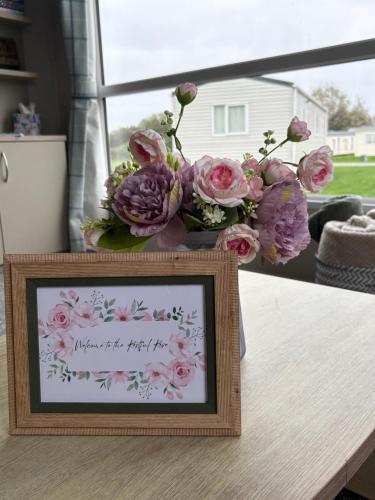 a picture of flowers in a frame on a table at The Restful Rose at Chichester Lakeside in Chichester