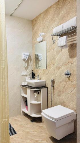 a bathroom with a toilet and a sink at Amritara Ramila Kutir Ayodhya in Ayodhya