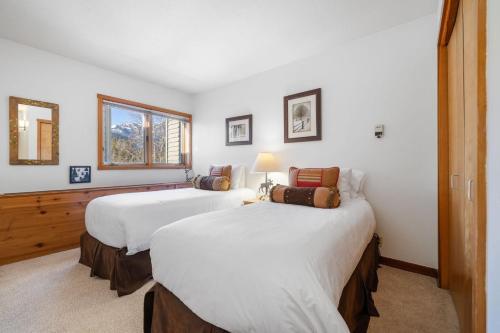 ウィルソンにあるRMR: Wheatgrass 2222 Condo in The AspensWilsonWYのベッド2台と窓のある寝室