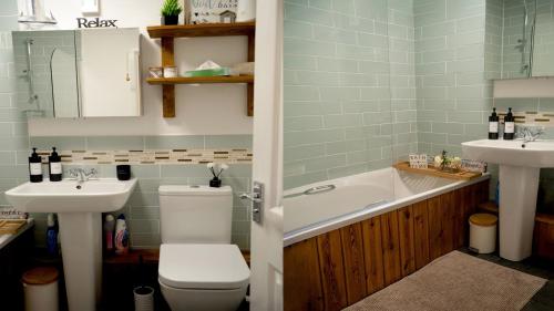 a bathroom with a tub and a toilet and a sink at Country Style, 2 bedroom house, Parking and superb location in Norwich