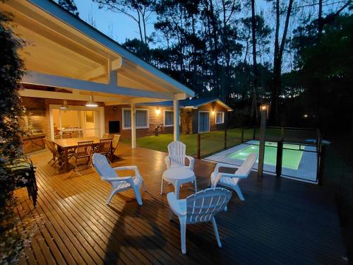 a deck with chairs and a table and a pool at Casa grande Carilo in Carilo