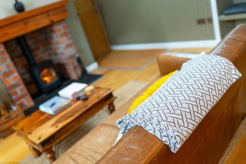 a living room with a couch and a fireplace at The Granary in Dunira