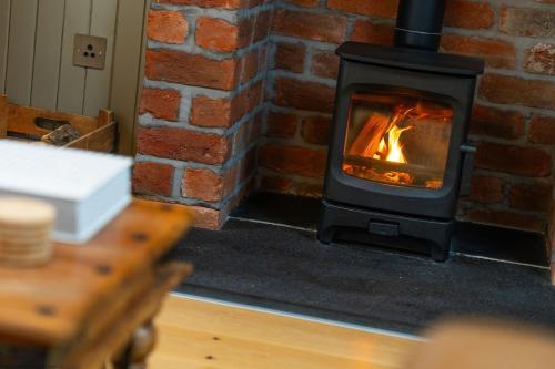 a brick fireplace with a fire in it at The Granary in Dunira