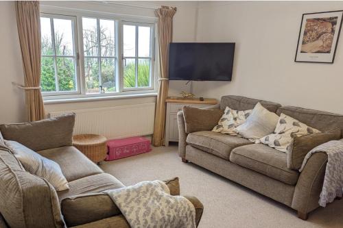 a living room with two couches and a tv at 2 Bed Cottage - Sleeps 4 - Garden Pets Wifi in Newton Abbot