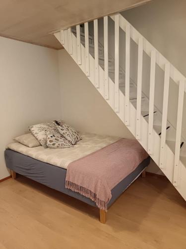 a bed in a room with a stair case at Rivitalo kylpylän lähellä in Kilvakkala