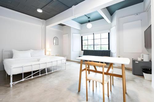 a bedroom with a bed and a table and chairs at Yellow Place Sukhumvit Soi 2 - เยลโล เพลส สุขุมวิทซอย 2 Pro in Bang Kapi