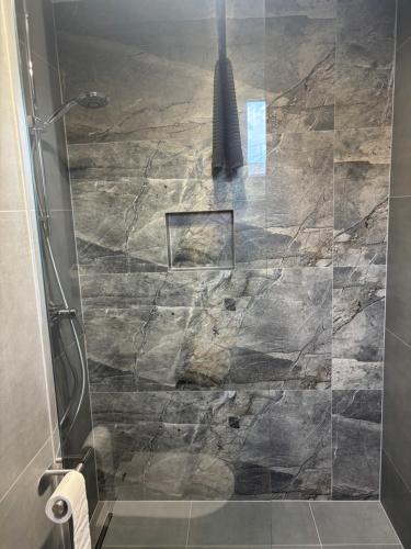 a bathroom with a shower with a stone wall at Nowy Zakątek in Kobyla Góra