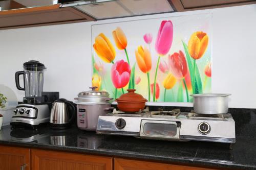 a kitchen counter with a painting of flowers on the wall at Tropical apartment no 7 in Nugegoda