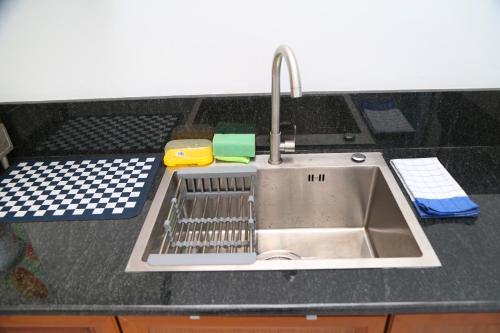 a kitchen sink with a dish rack next to it at Tropical apartment no 7 in Nugegoda