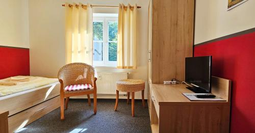 海利根达姆Mollibahnhof - Heiligendamm Mollibahnhof Heiligendamm EZ 03的一间卧室，配有一张床和一张带电视的书桌
