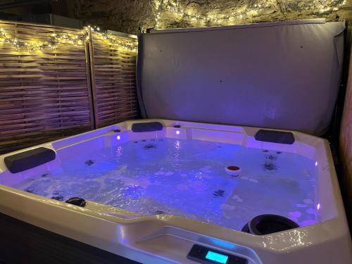 una vasca idromassaggio in una stanza con luci di Cosy home quartier gare lafayette avec spa et sauna privatif ad Angers